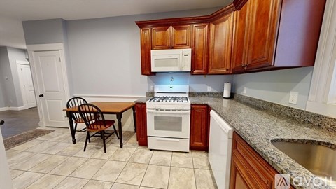 A kitchen with a table and chairs.