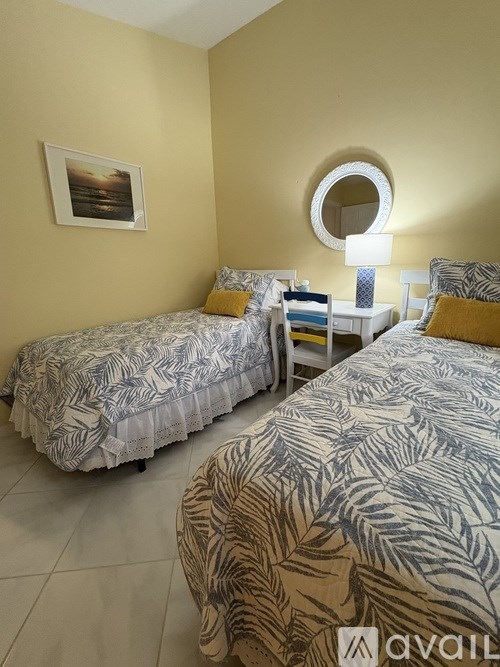 Two twin beds with matching bedding in a room with tan walls.