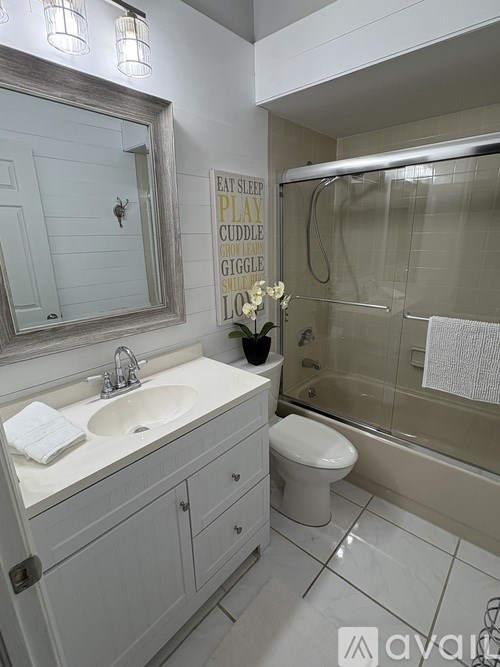 A bathroom with a sink, toilet, and a mirror.