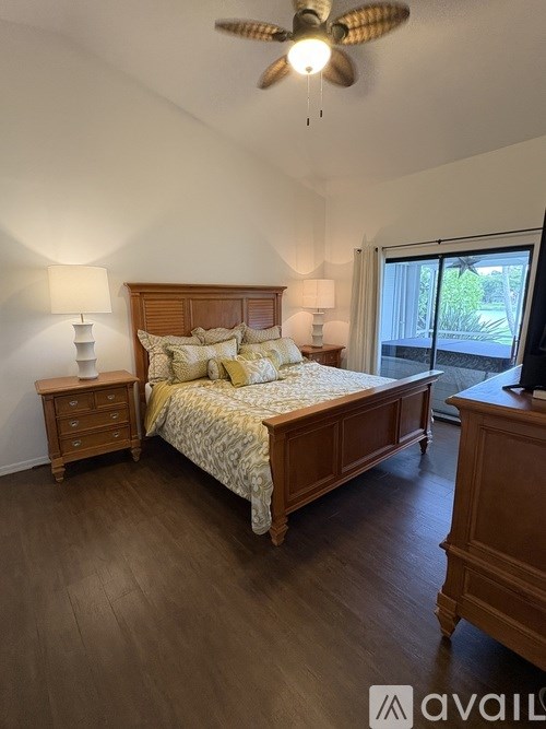 A bedroom with a bed, nightstand, and a ceiling fan.