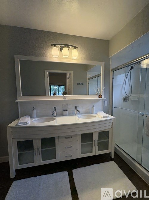 A bathroom with a white vanity and a mirror above it.