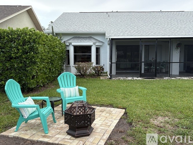 Two chairs and a table are on a patio.
