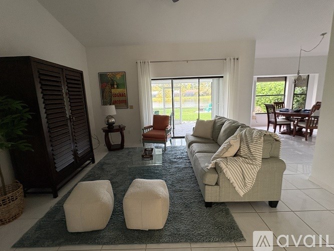 A living room with a couch, chairs, and a rug.