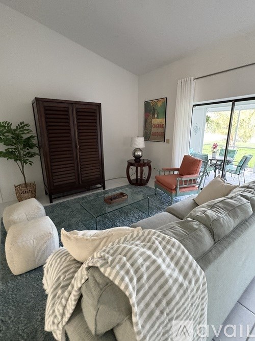 A living room with a grey couch and a glass coffee table.