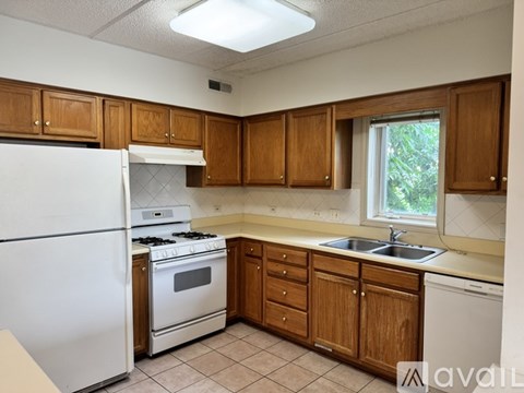 A kitchen with wooden cabinets and a white refrigerator.