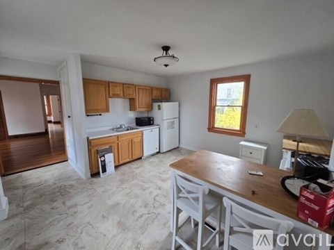 A kitchen with wooden cabinets and a white fridge.