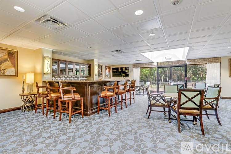 A well-lit room with a bar and chairs.