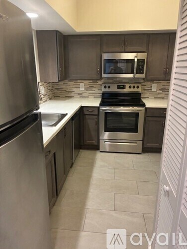 A modern kitchen with a stainless steel refrigerator and oven.