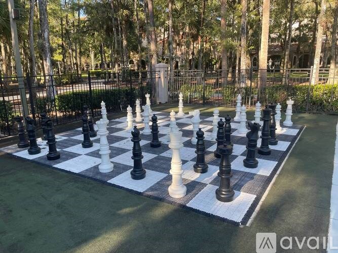 A giant chess set is set up on a green lawn.