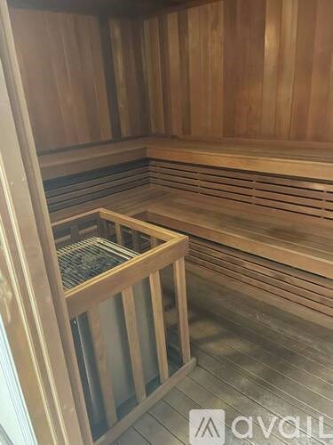 A wooden sauna with a glass door and a bench inside.