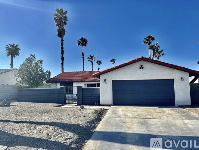 A house with a red roof and a garage door is for sale.