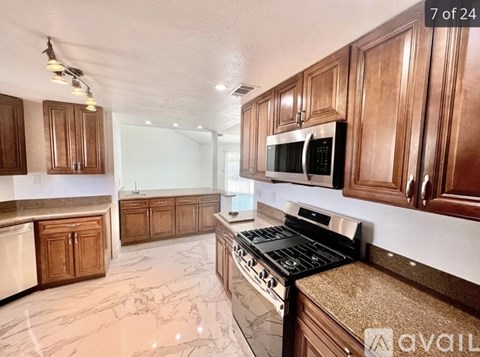 A kitchen with brown cabinets and a black stove top oven.