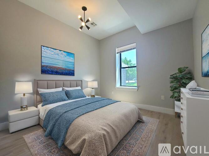 A bedroom with a large bed and a painting on the wall.