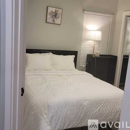 A white bed with a black headboard and two pillows.