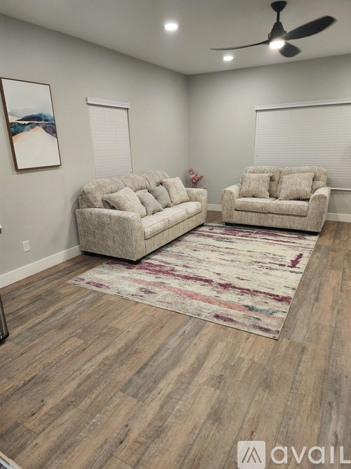 A living room with two couches and a rug.