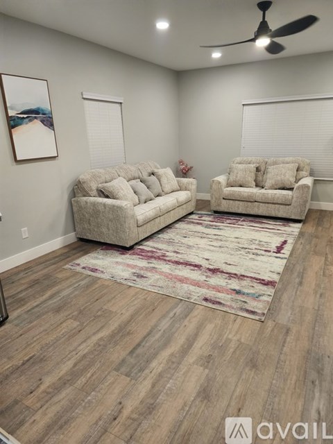 A living room with two couches and a rug.