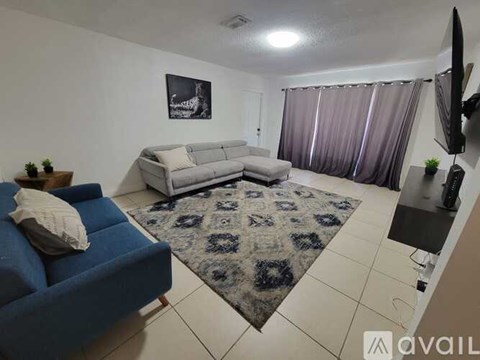 A living room with a blue couch and a grey sofa.