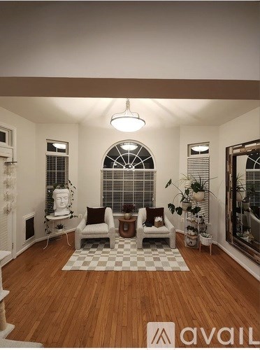 A living room with a checkered rug and two chairs.