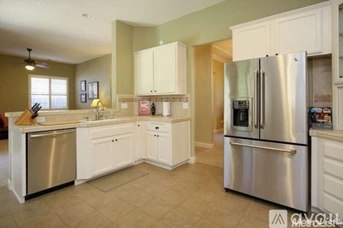 A kitchen with white cabinets and stainless steel appliances.