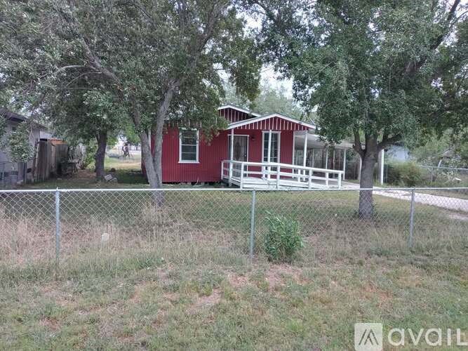 A red house with a white fence in front of it.