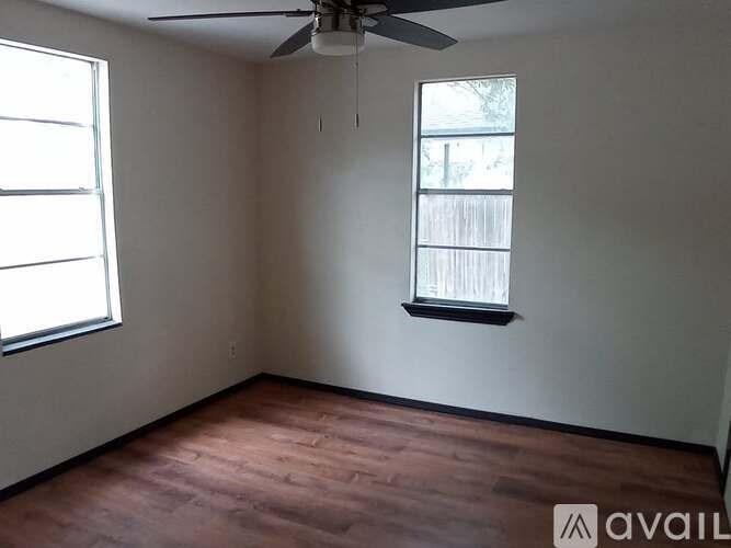 A room with a ceiling fan and a window with blinds.