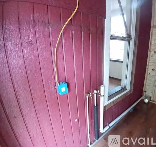 A wall socket with a blue cover is on a red wall.