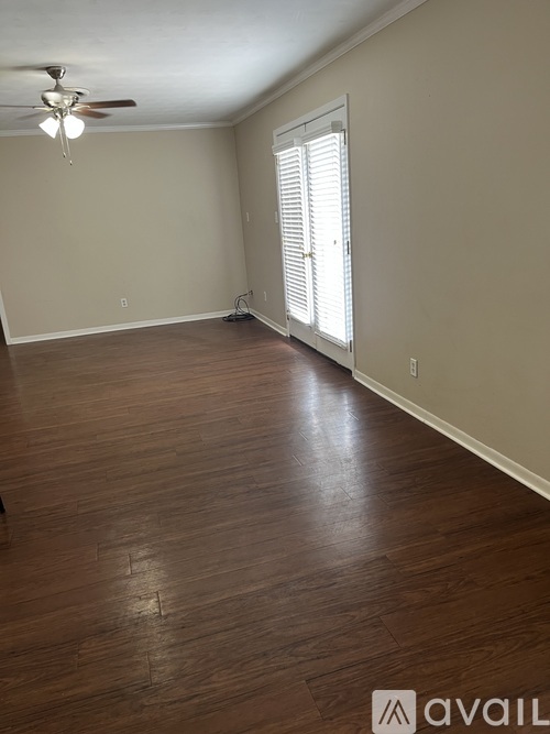 A room with wooden flooring and a ceiling fan.