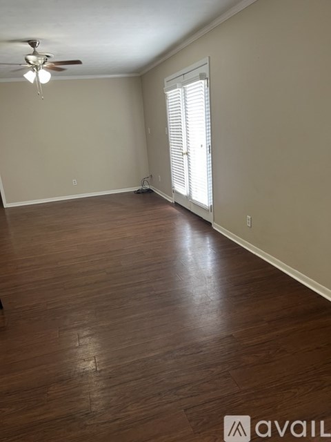 A room with wooden flooring and a ceiling fan.