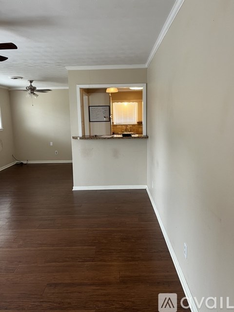 A room with a window and a fan on the ceiling.