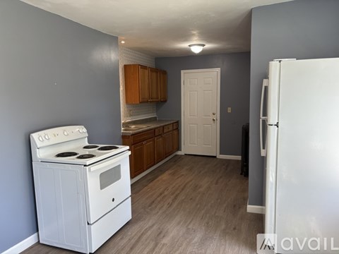 A kitchen with a white stove and wooden cabinets.