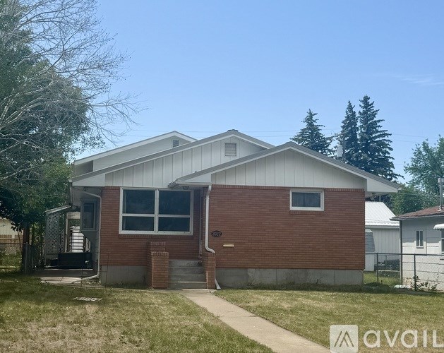 A house with a red brick exterior and a white roof is for sale.