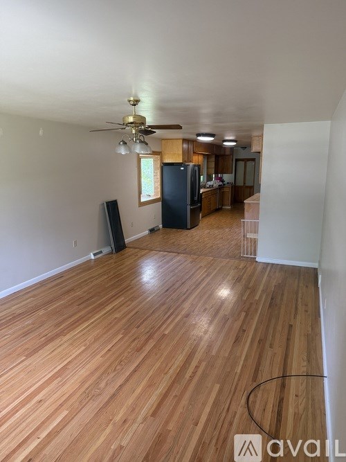 A room with wooden floors and a ceiling fan.