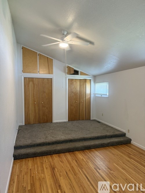 A room with wooden floors and a ceiling fan.