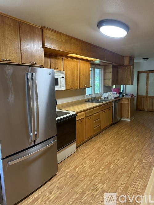A kitchen with wooden cabinets and a stainless steel refrigerator.