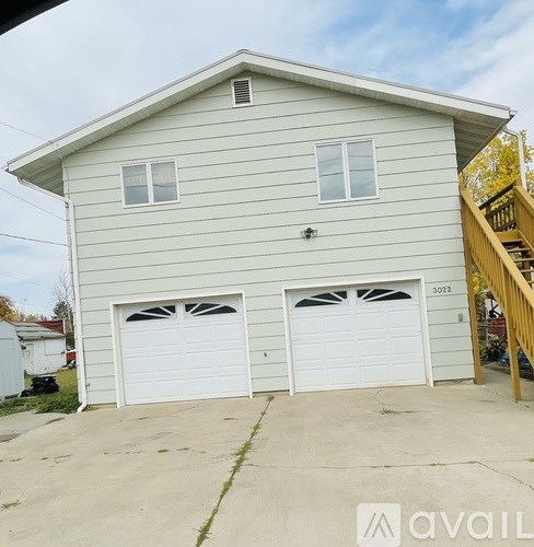 A two-car garage is attached to a light-colored house.