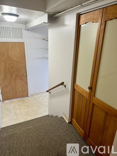 A room with a wooden door and a carpeted floor.
