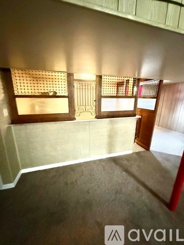 A room with a carpeted floor and two windows.