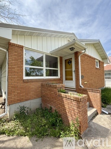 A small house with a white roof and a brick wall.