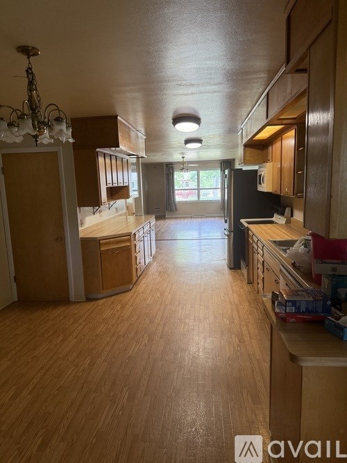 A kitchen with wooden floors and a chandelier.