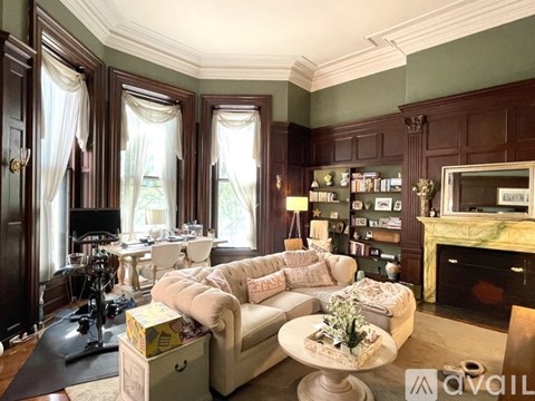 A living room with a white couch and a fireplace.