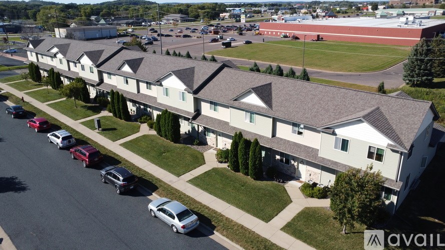 A row of houses with cars parked in front.