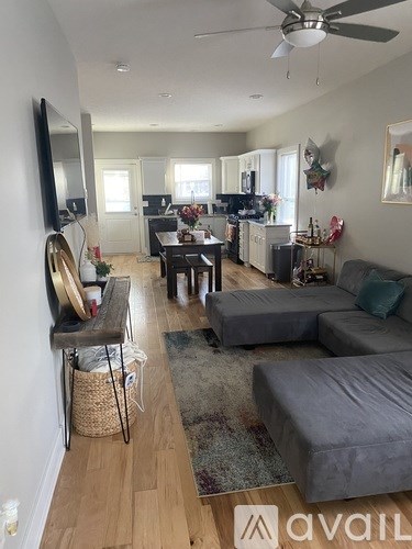 A living room with a grey couch and a television on the wall.