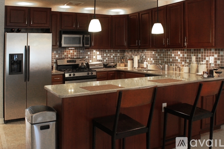 A kitchen with brown cabinets and a white refrigerator.