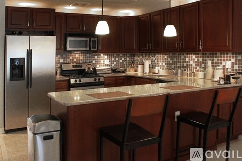 A kitchen with brown cabinets and a white refrigerator.