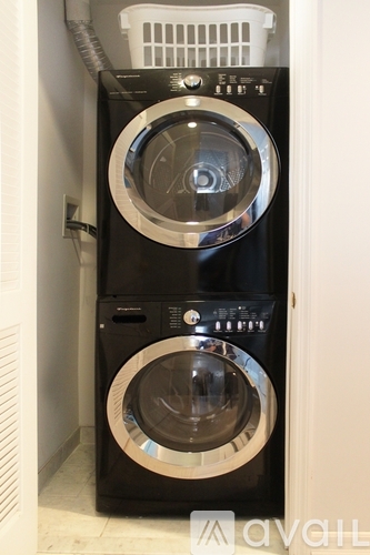 A black front loading washing machine with a basket on top.