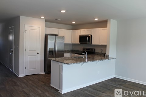 A kitchen with a granite countertop and stainless steel appliances.