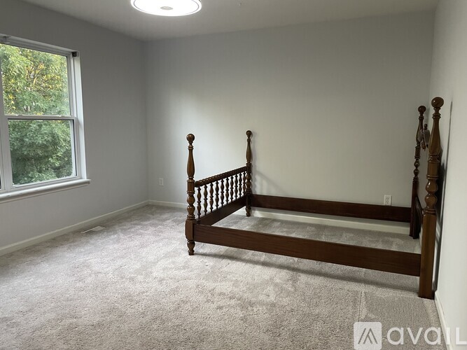 A bedroom with a large bed and a window.