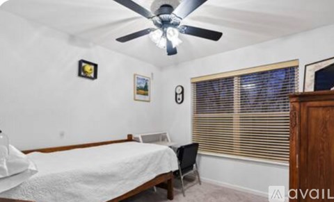 A spacious room with a ceiling fan and a sign that says "AVAIL".
