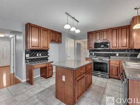 A kitchen with wooden cabinets and a granite countertop.
