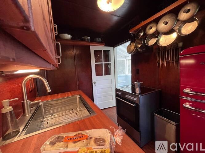 A kitchen with a wooden counter top and a red oven.